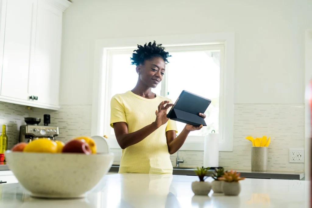 An older woman smiling on her tablet while she books an AC repair and maintenance with One Hour Heating and Air Conditioning- Phoenix West Valley.