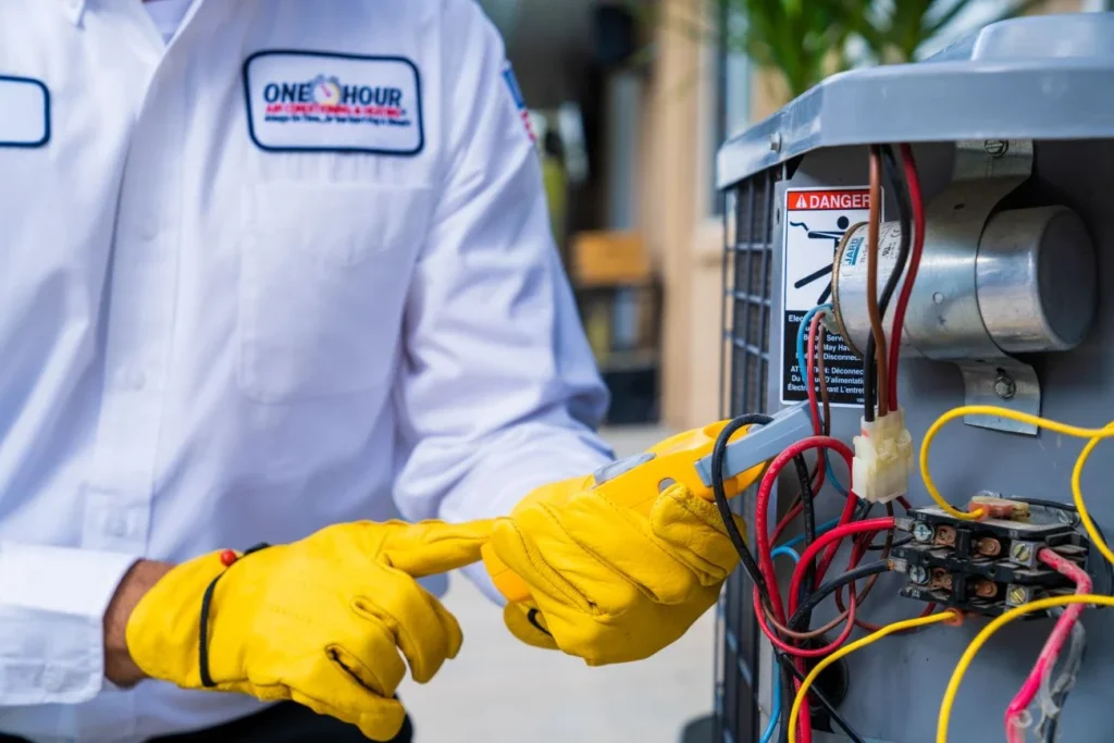 One Hour Heating and Air Conditioning tech working on residential Phoenix West Valley HVAC maintenance on an indoor AC unit.
