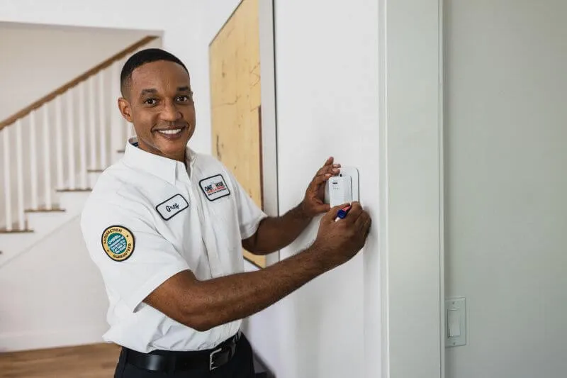 A One Hour Heating and Air Conditioning- Phoenix West Valley tech assessing an indoor thermostat after a routine AC maintenance in Sun City West, AZ