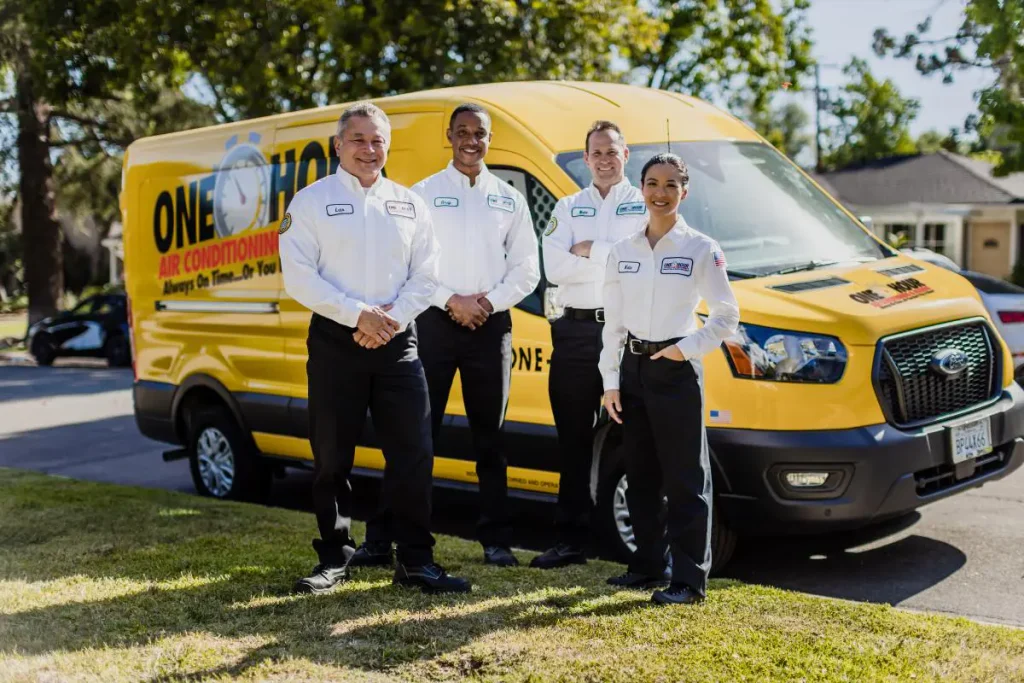 One Hour Heating and Air Conditioning techs smiling in front of a wrapped van after a free estimate call in Surprise, AZ.