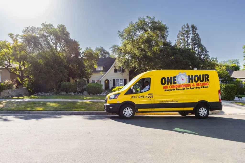 One Hour Heating and Air Conditioning tech parked outside a residential Phoenix West Valley home waiting to complete full AC repairs in a wrapped One Hour van.