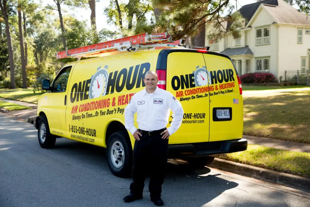 One Hour Heating and Air Conditioning- Phoenix West Valley tech smiling in front of wrapped van after an AC repair in Sun City, AZ.